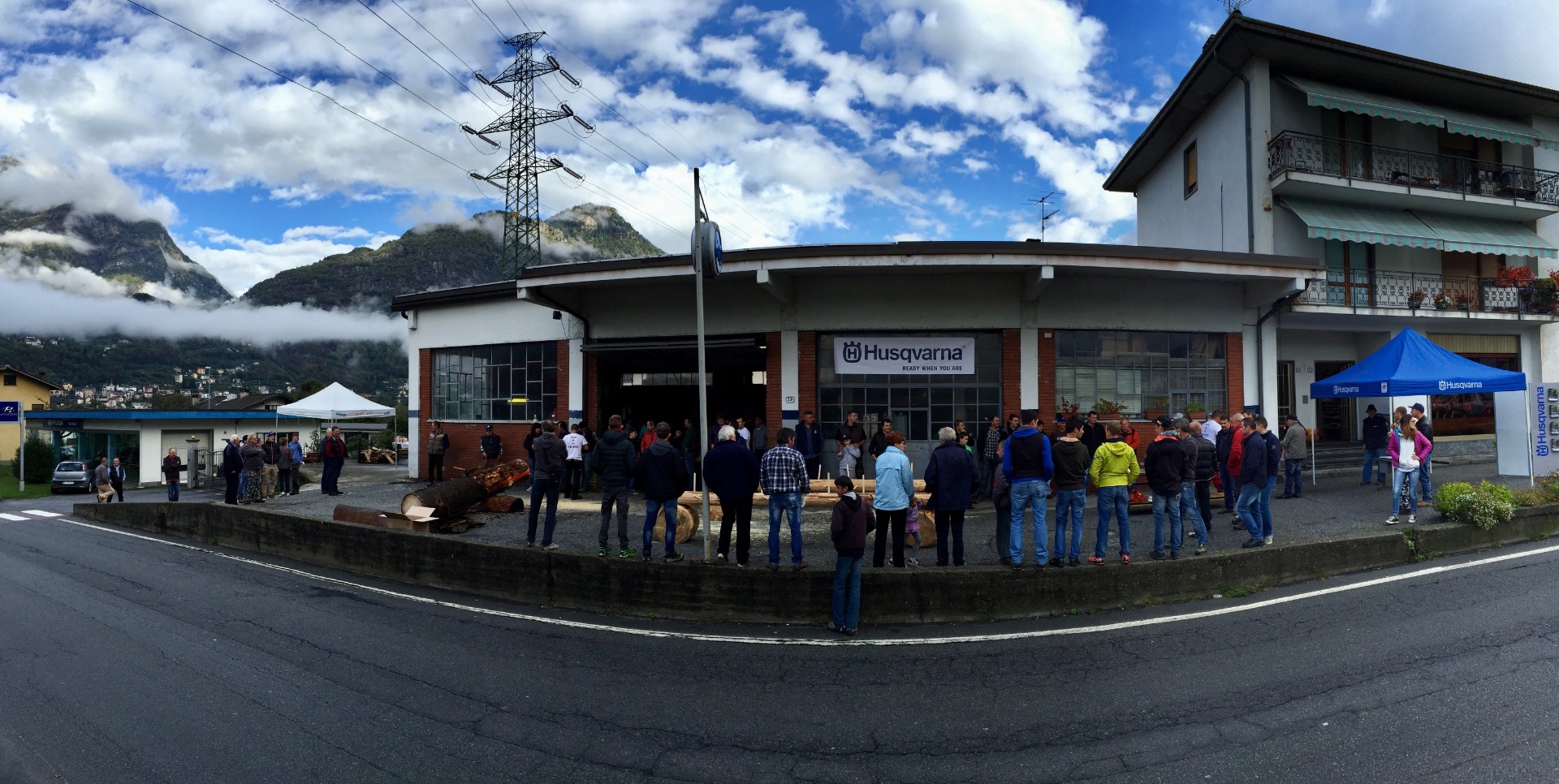 Vista panoramica dell'officina Agri Papa Nicolini a Montecrestese durante una demo Husqvarna, con le montagne della Val d'Ossola sullo sfondo