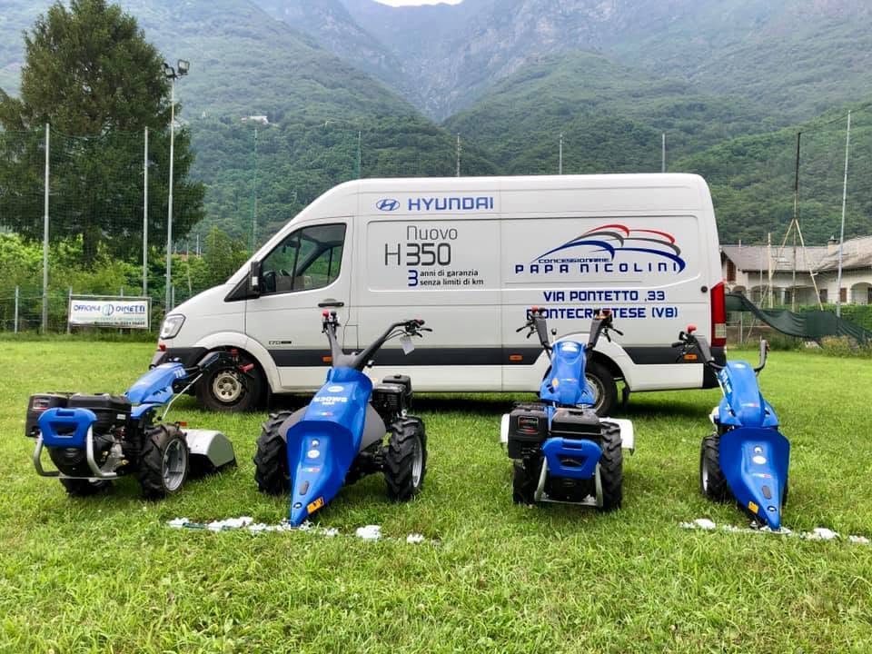 Furgone Concessionarie Papa Nicolini con la gamma di motocoltivatori BCS esposta sul prato in Val d'Ossola